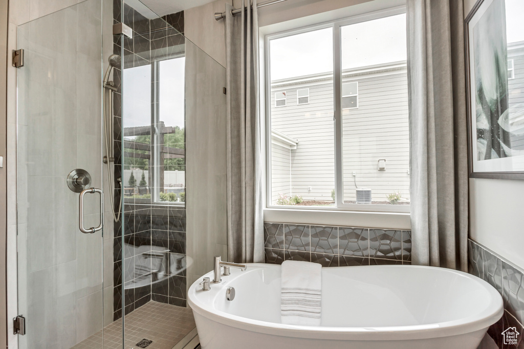 Full bathroom featuring a soaking tub and a stall shower