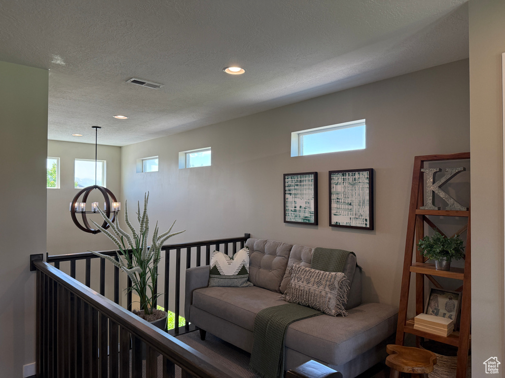 Living room featuring a chandelier, recessed lighting, and a textured ceiling