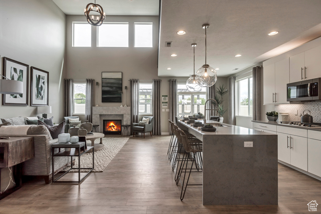 Kitchen with stainless steel appliances, open floor plan, a kitchen bar, healthy amount of natural light, and recessed lighting