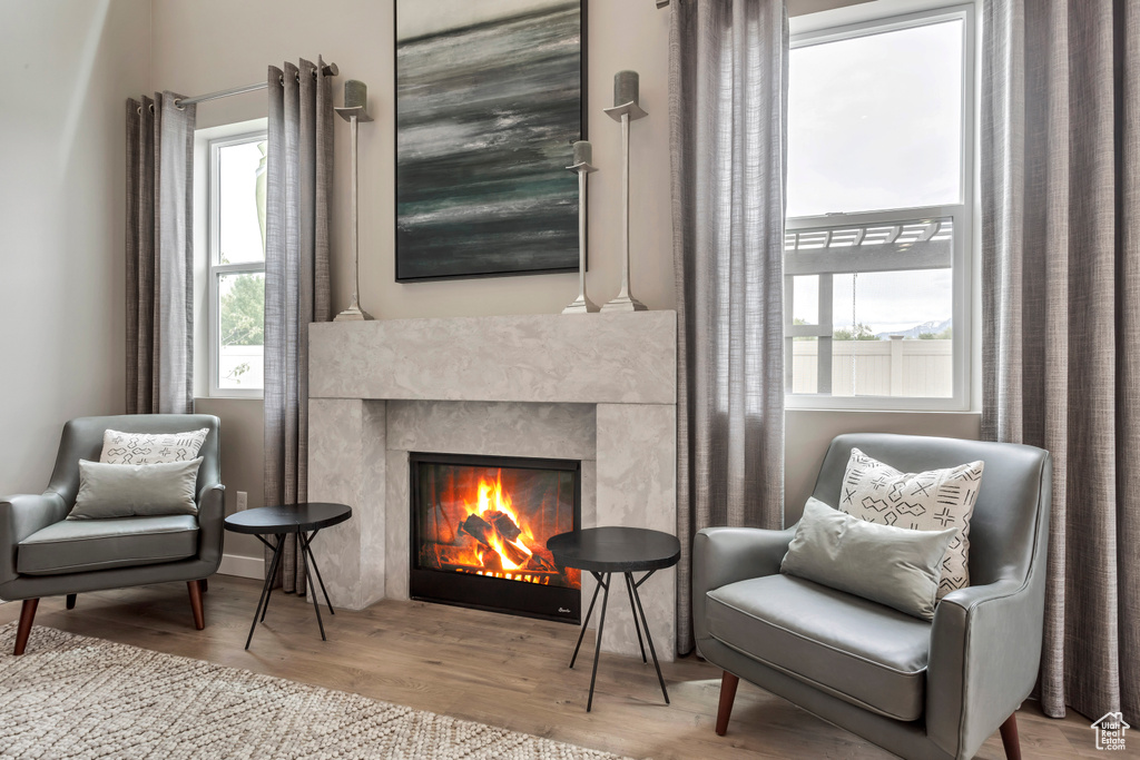 Living area with a warm lit fireplace and wood finished floors