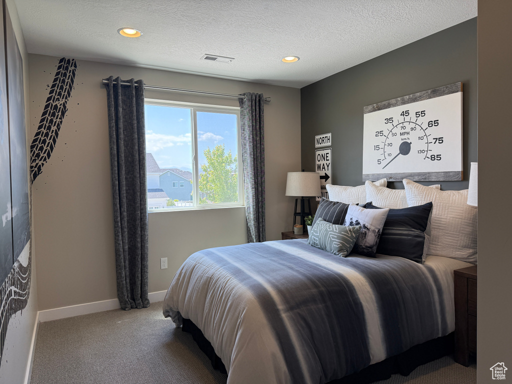 Carpeted bedroom with recessed lighting, baseboards, and a textured ceiling