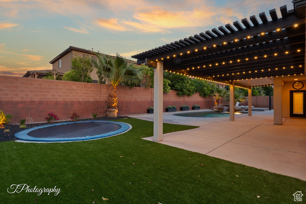 View of yard with a trampoline and a patio area