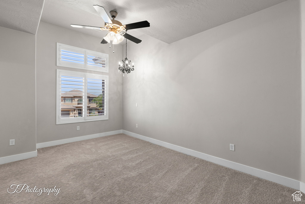 Unfurnished room with a ceiling fan, light colored carpet, baseboards, and a textured ceiling
