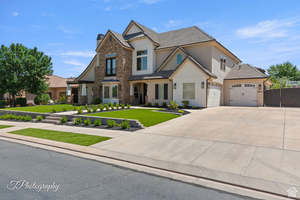 Craftsman house featuring board and batten siding, concrete driveway, an attached garage, stone siding, and a tiled roof