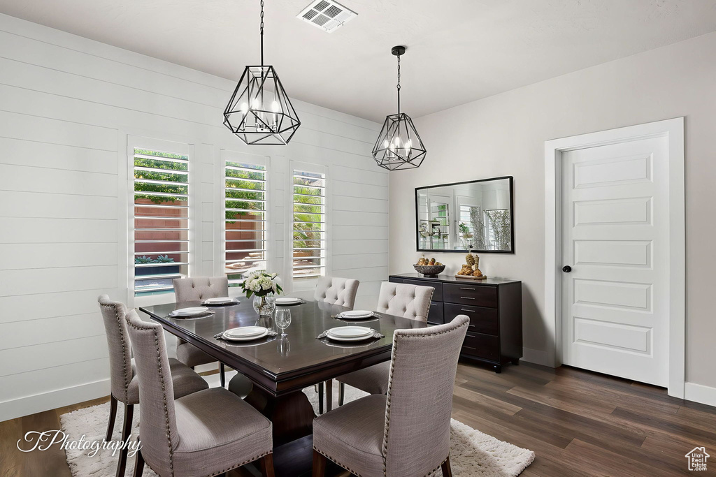 Dining area with dark wood finished floors, a chandelier, and baseboards