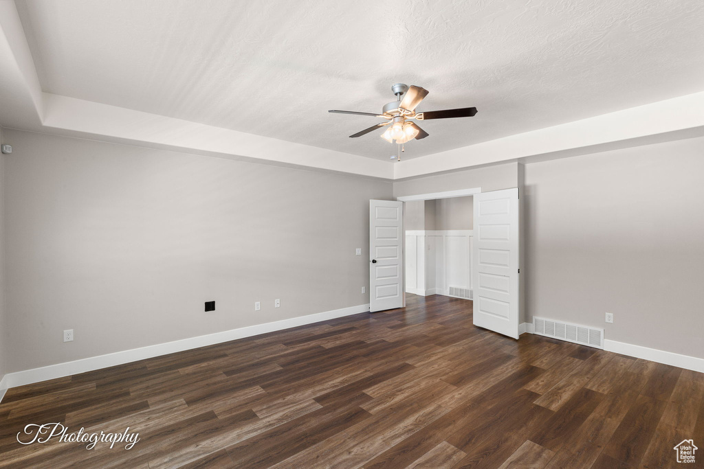 Unfurnished bedroom with baseboards, dark wood finished floors, and a ceiling fan
