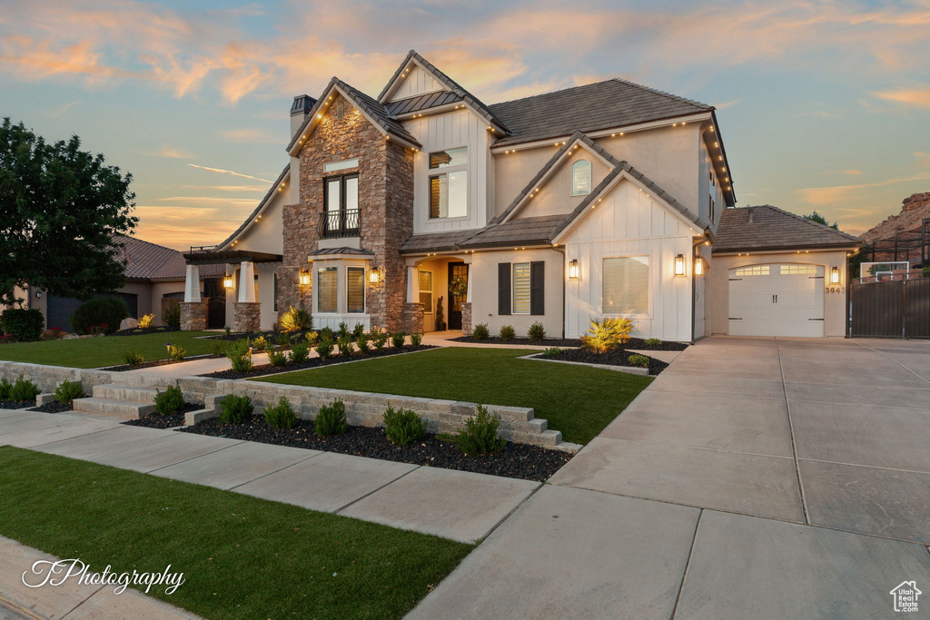 View of front of home featuring board and batten siding, stone siding, concrete driveway, and stucco siding