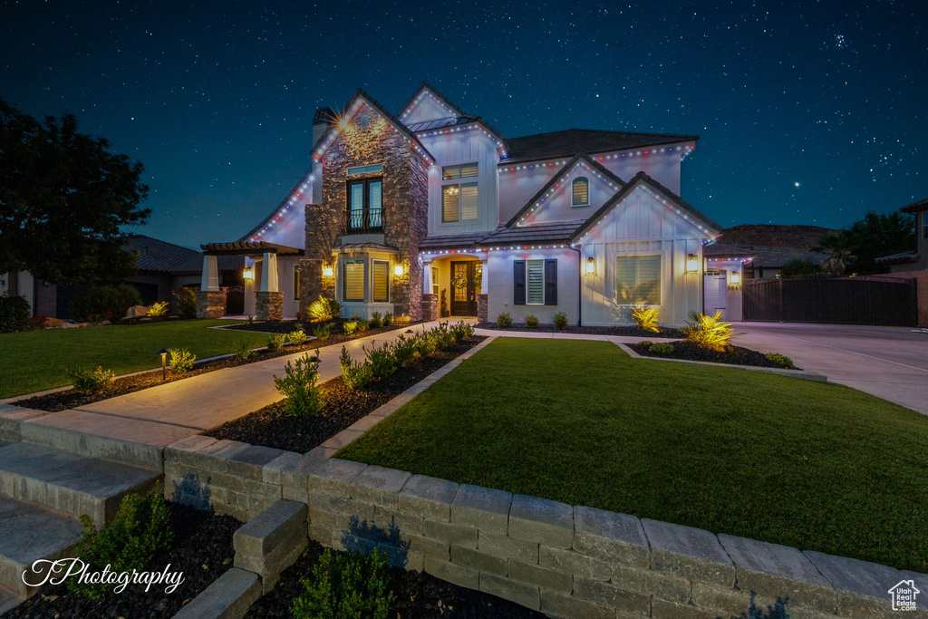 View of front of home featuring a lawn and board and batten siding