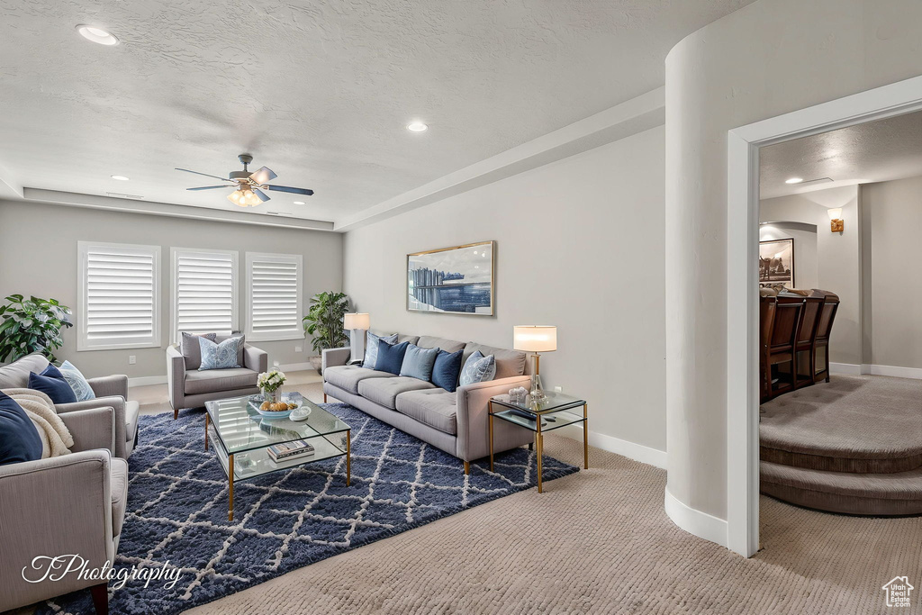 Living room featuring a ceiling fan, carpet, baseboards, and recessed lighting