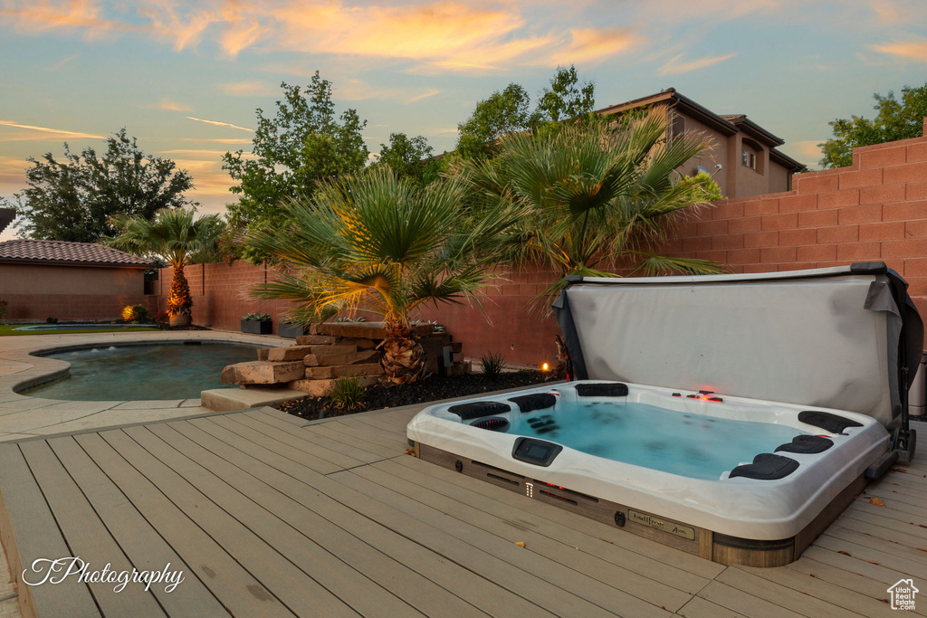 View of pool with a wooden deck and a fenced backyard