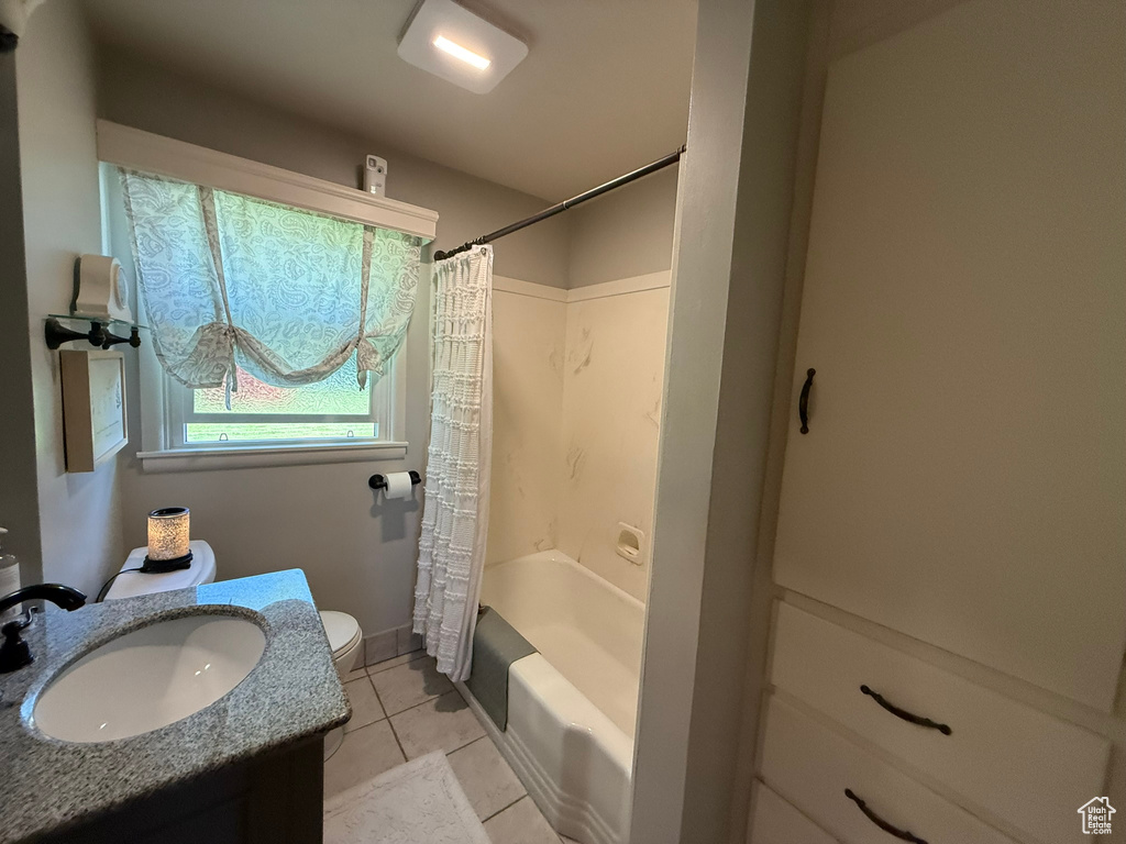 Bathroom featuring toilet, tile patterned floors, shower / bath combination with curtain, and vanity