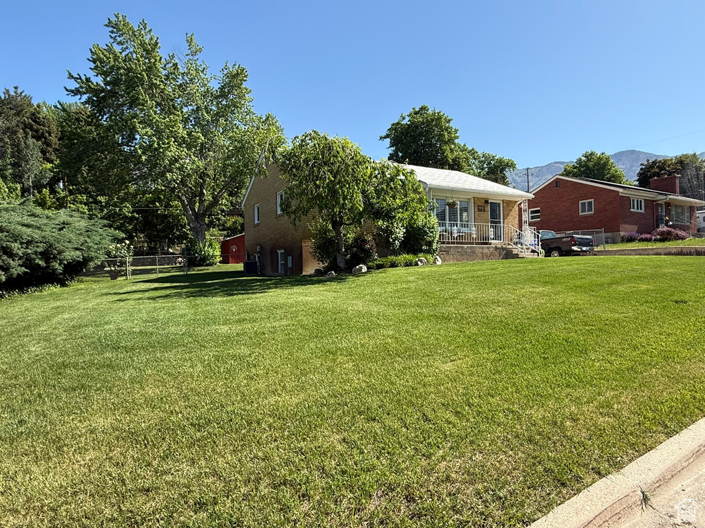 View of front of property featuring a front yard, brick siding, and a mountain view