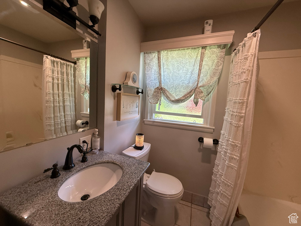 Full bath with toilet, vanity, tile patterned flooring, and shower / bath combo with shower curtain