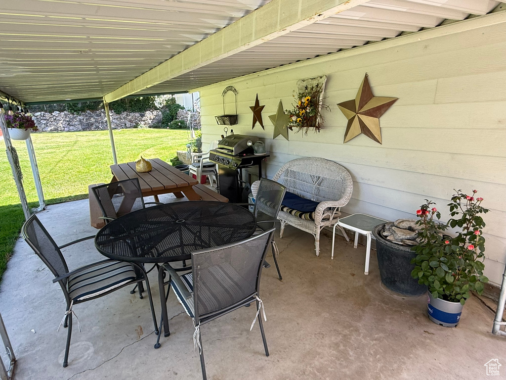 View of patio with outdoor dining space and a grill