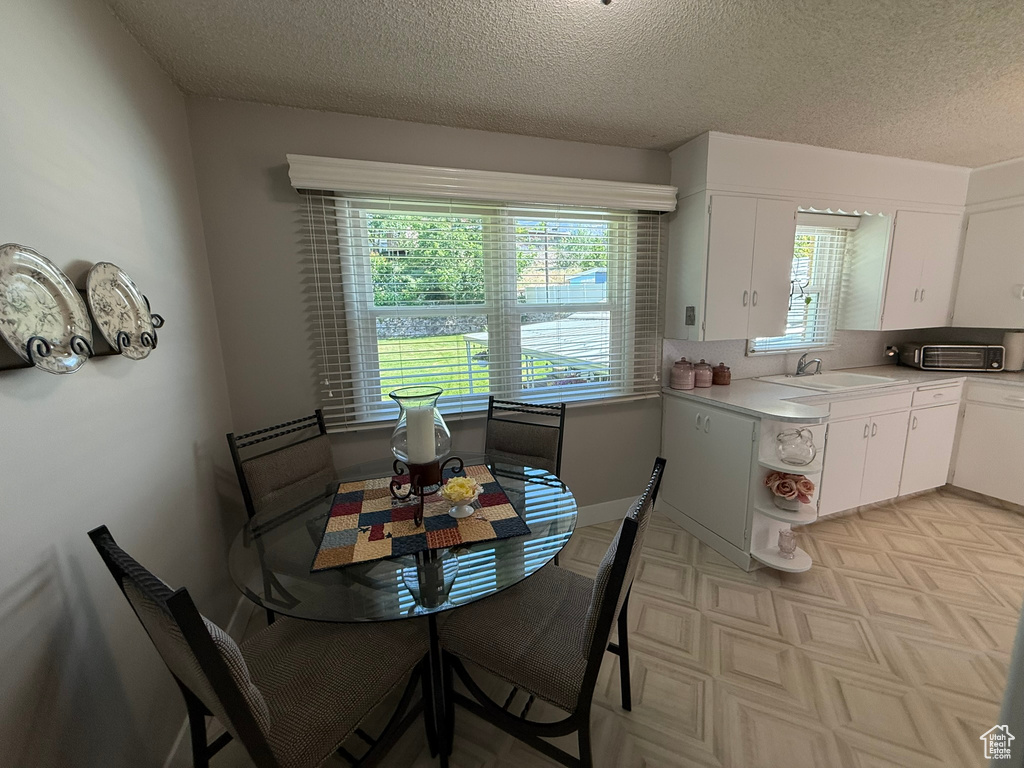 Dining space featuring a textured ceiling and light floors