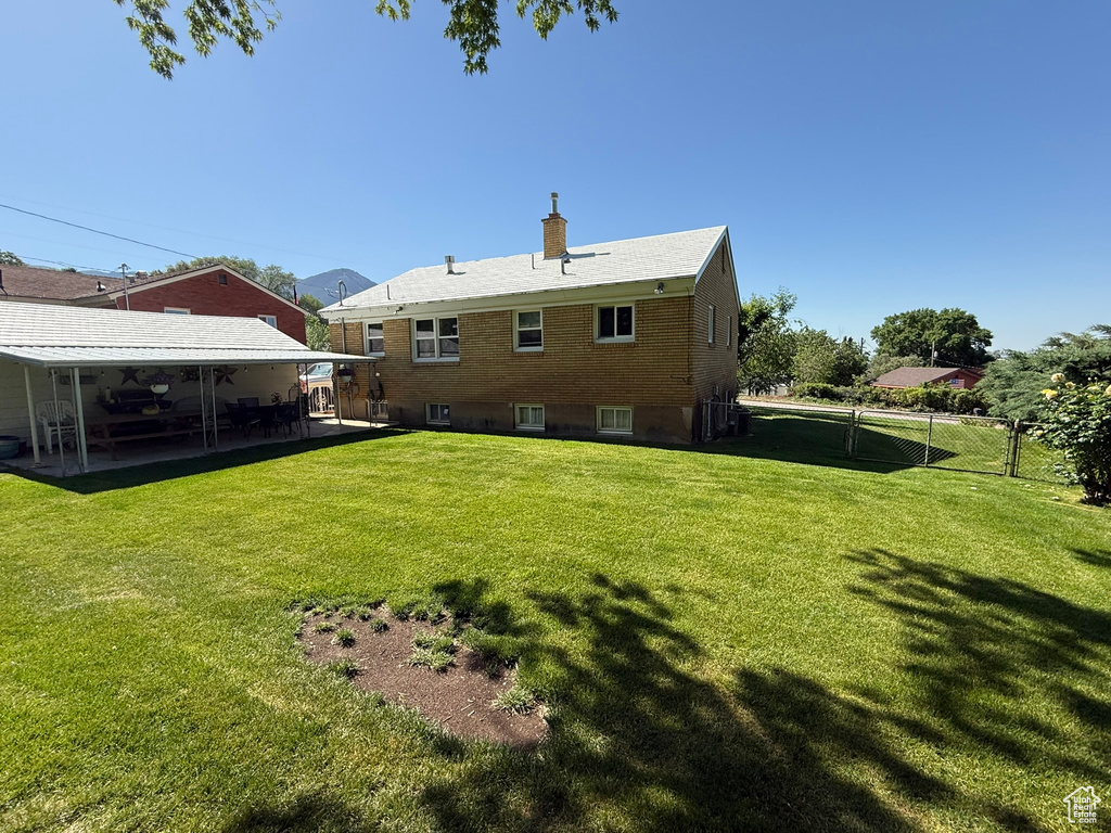 Rear view of property with a chimney, a patio area, and brick siding