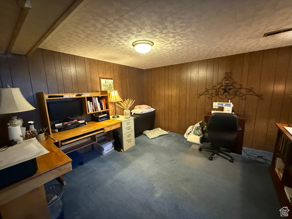 Office space with carpet flooring and wood walls