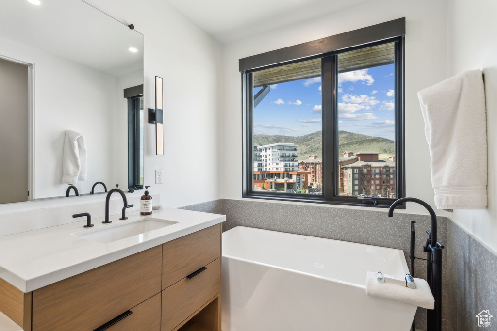 Full bath with a freestanding bath, vanity, and recessed lighting