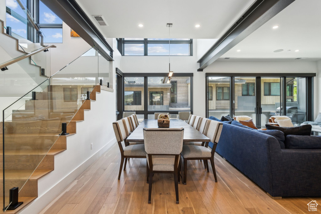 Dining room featuring hardwood / wood-style floors, stairs, baseboards, and recessed lighting
