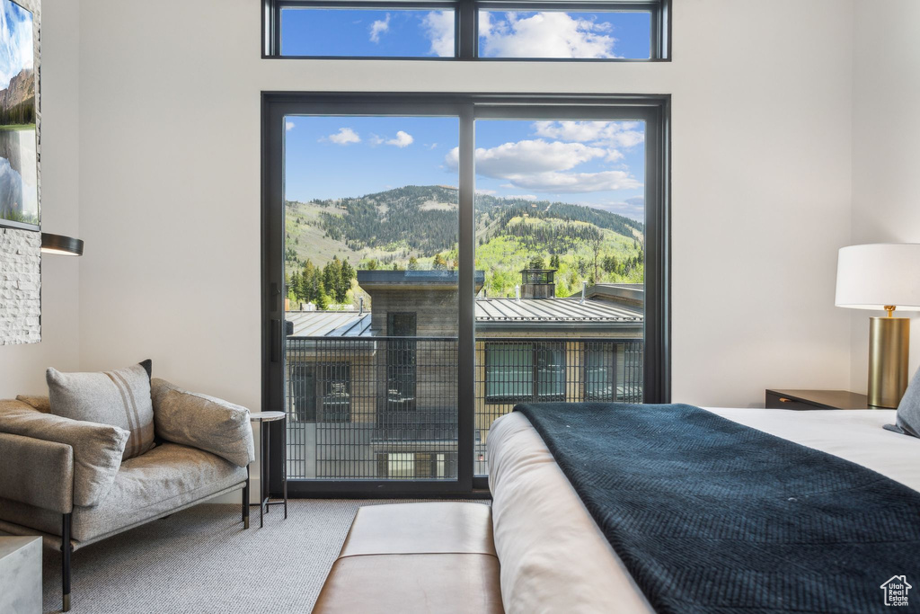 Carpeted bedroom with a mountain view and access to outside