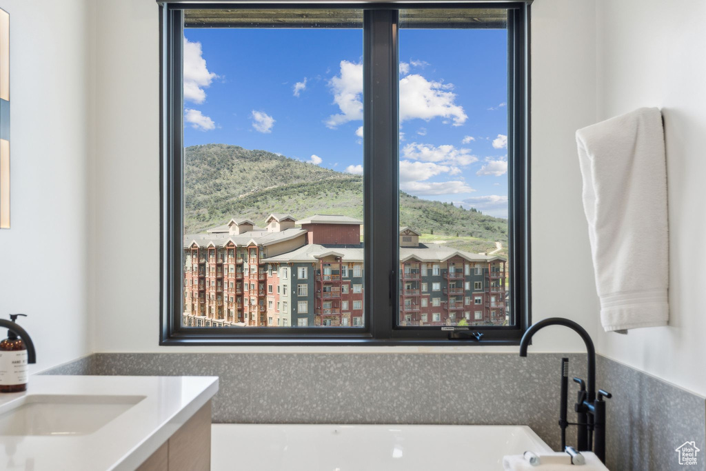 Full bathroom featuring plenty of natural light, vanity, a mountain view, and a bath