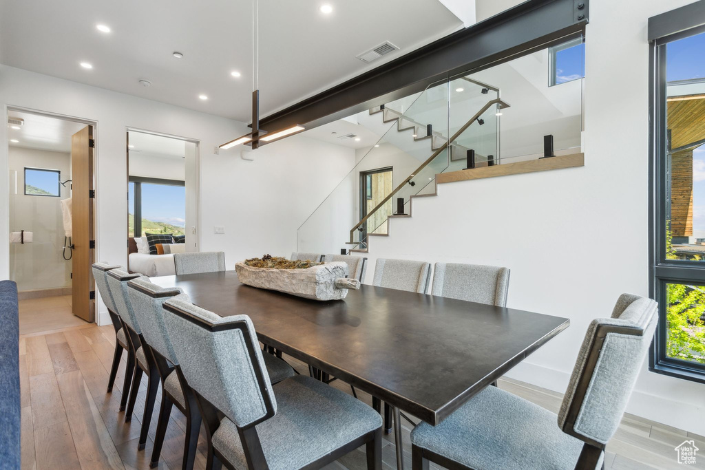 Dining room featuring stairs, light wood finished floors, plenty of natural light, recessed lighting, and baseboards