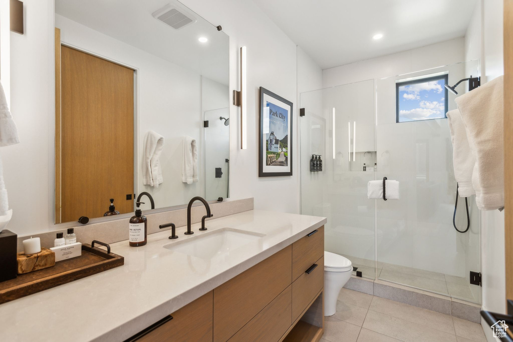 Full bathroom featuring vanity, toilet, a stall shower, tile patterned flooring, and recessed lighting