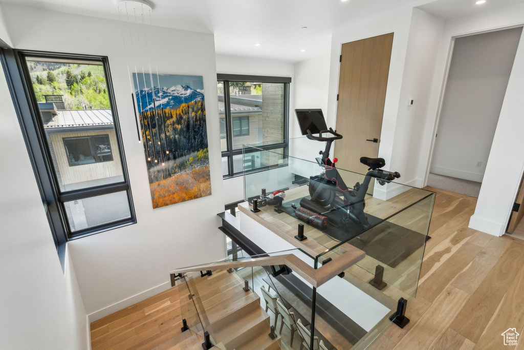 Exercise area with light wood-style flooring, baseboards, and recessed lighting