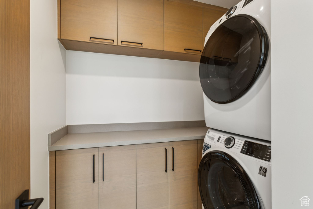 Washroom with cabinet space and estacked washer and dryer