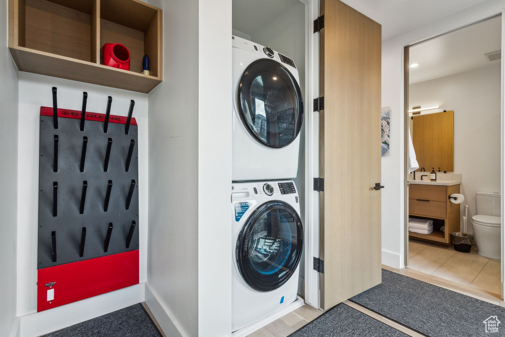 Washroom featuring estacked washer and dryer and tile patterned flooring