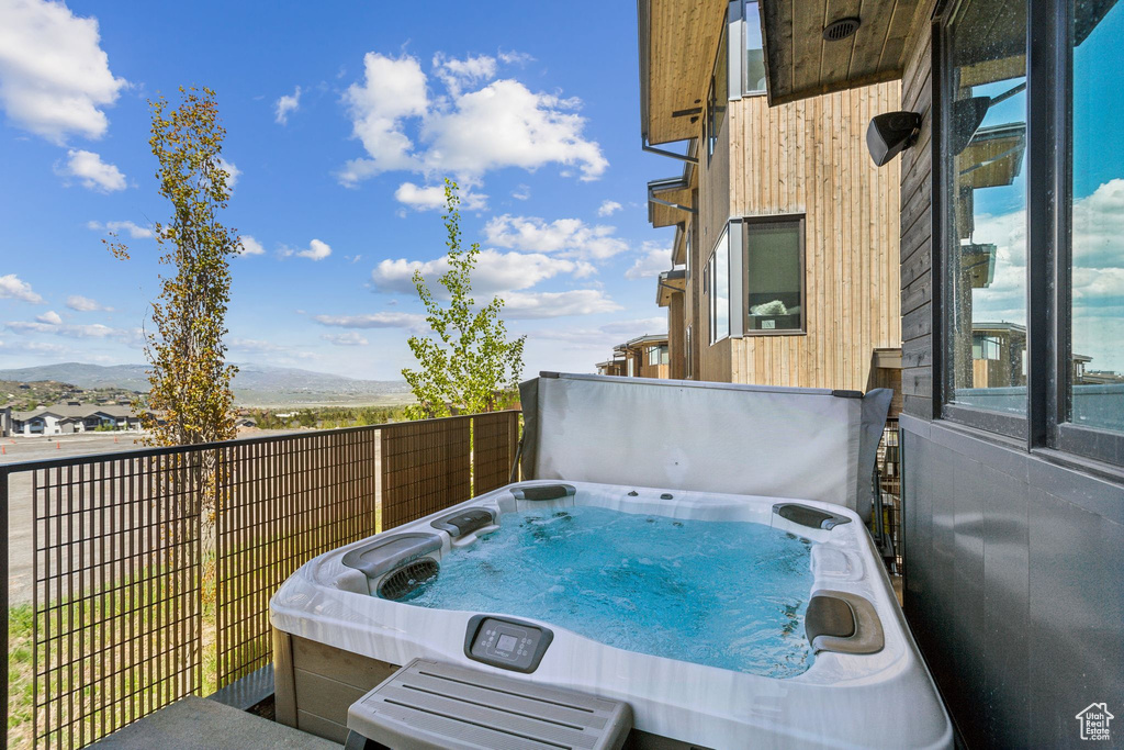 View of patio / terrace with a hot tub and a mountain view