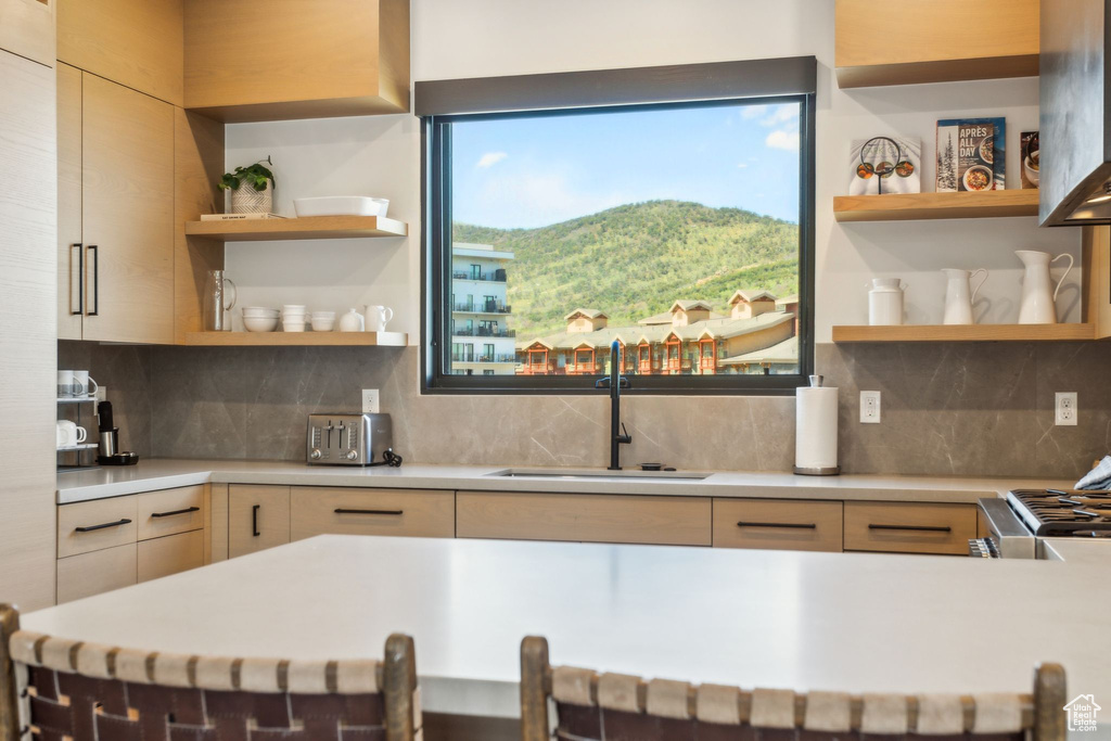 Kitchen featuring open shelves, a sink, light countertops, and a mountain view