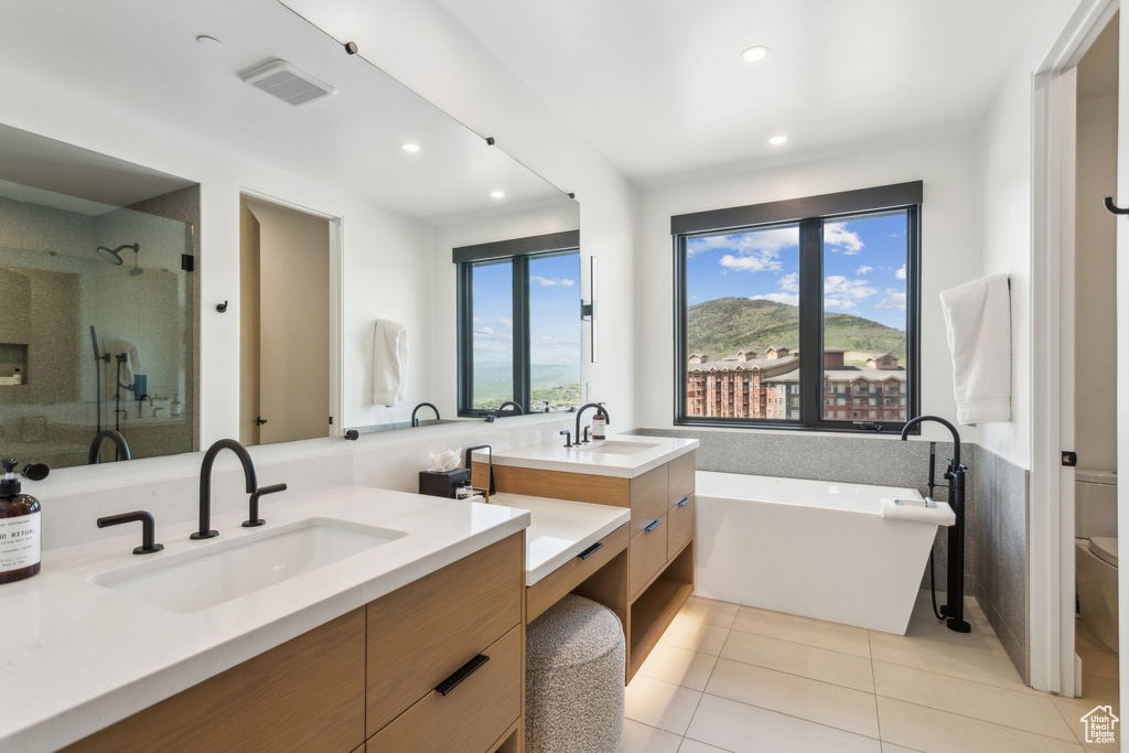 Bathroom with vanity, tile patterned floors, a freestanding tub, recessed lighting, and a stall shower