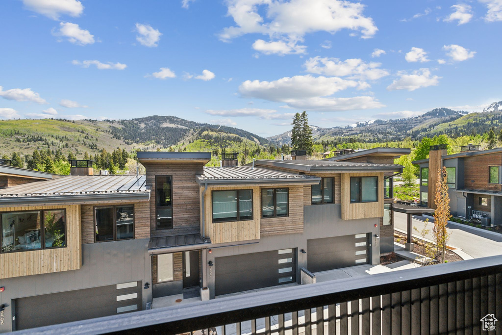 View of front facade featuring a standing seam roof, a mountain view, an attached garage, and metal roof