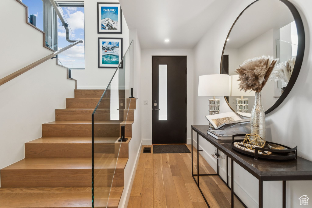 Foyer entrance featuring light wood-style flooring, stairs, baseboards, and recessed lighting