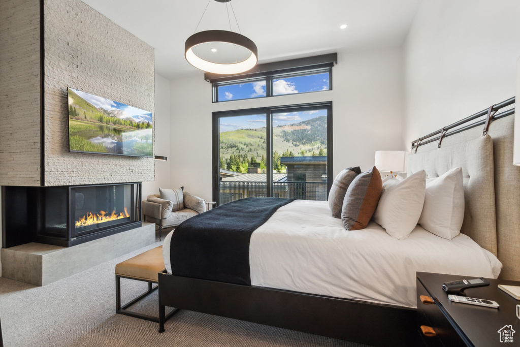 Carpeted bedroom featuring access to exterior, a fireplace, and recessed lighting