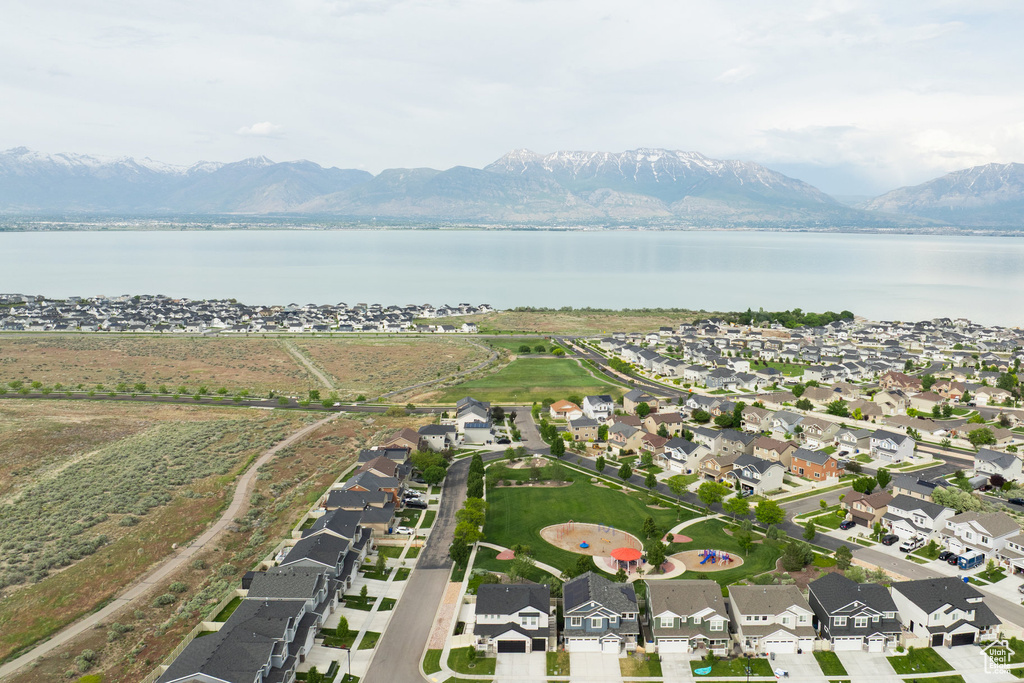 Aerial view of property's location with a water and mountain view and nearby suburban area