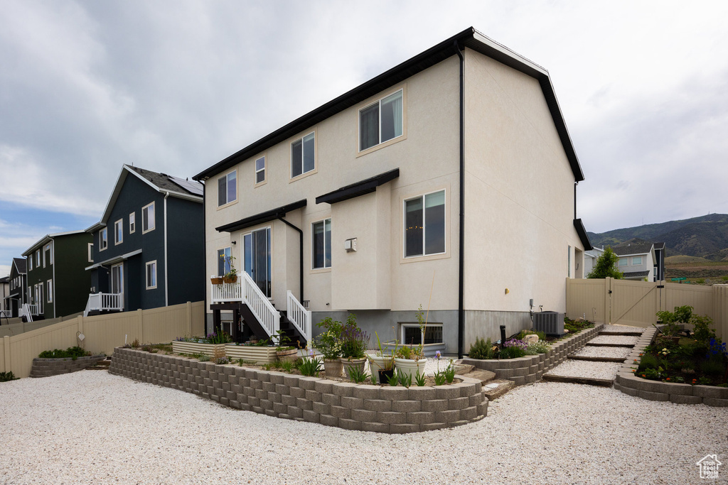 Rear view of house featuring a gate, stucco siding, central air condition unit, and a patio area