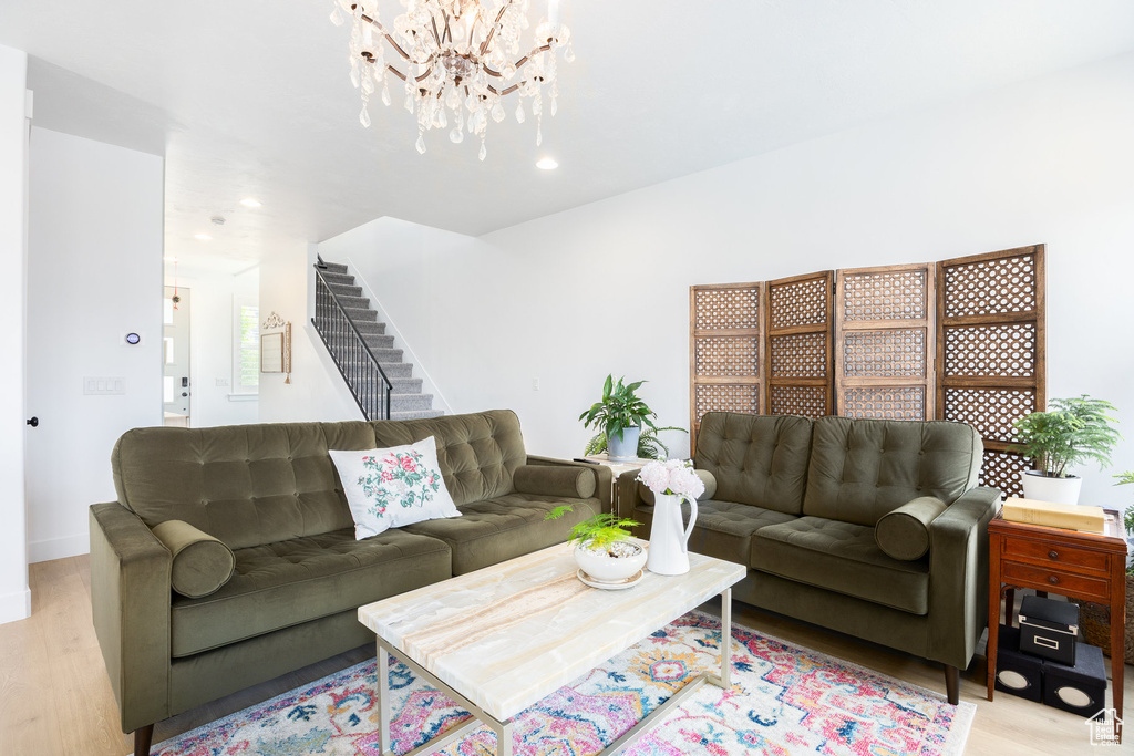 Living area featuring light wood-style floors, stairs, a chandelier, and recessed lighting