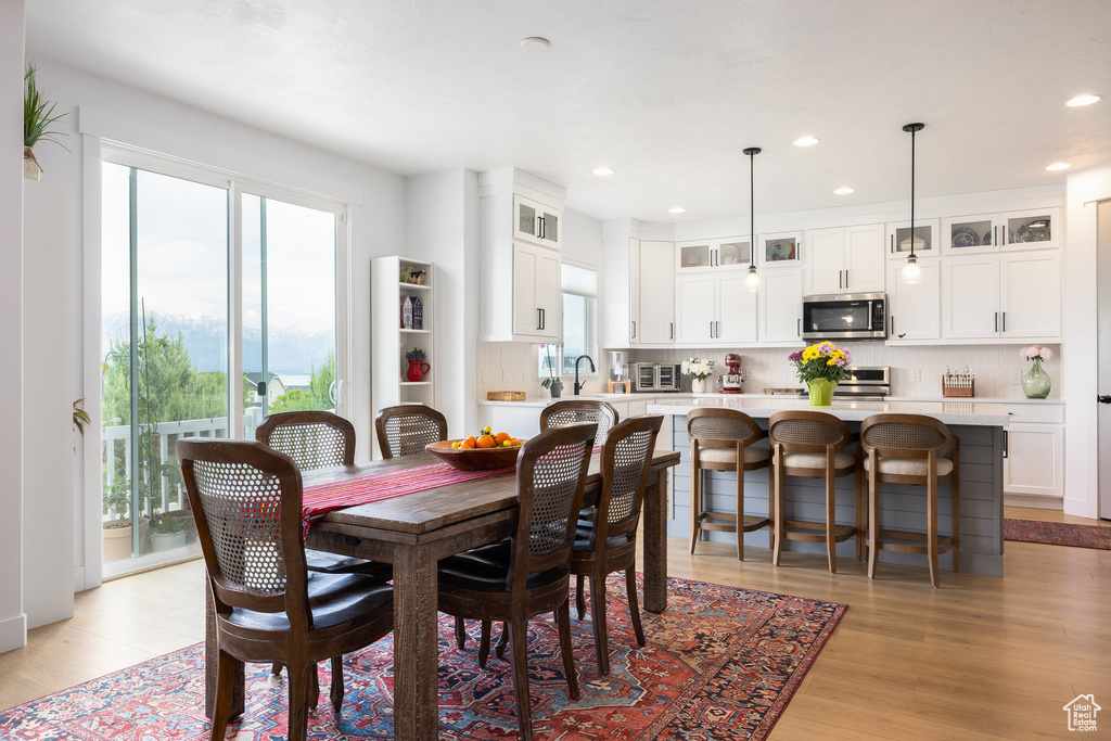 Dining room featuring healthy amount of natural light, light wood-type flooring, and recessed lighting