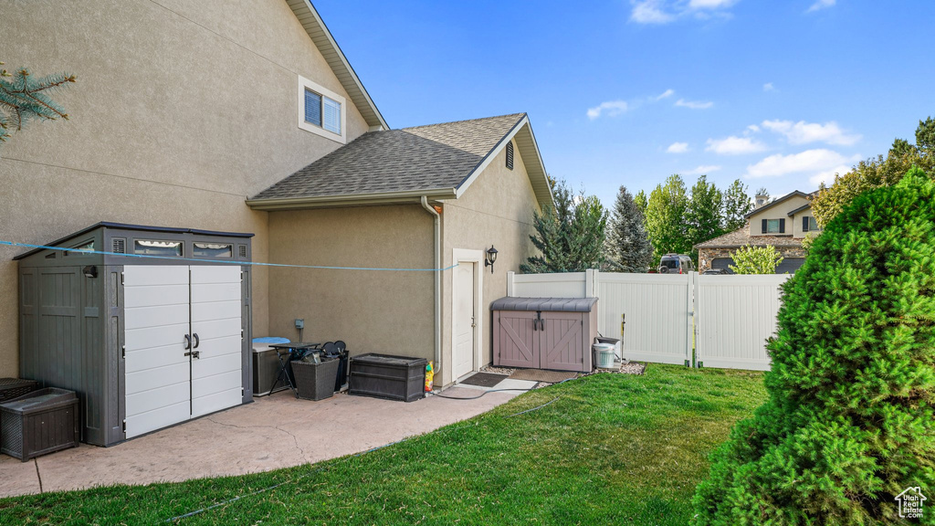 View of home\'s exterior with stucco siding, a gate, and a shingled roof