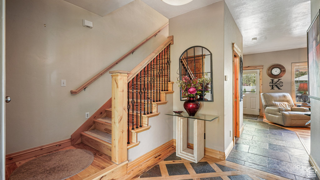 Staircase featuring baseboards and stone tile floors
