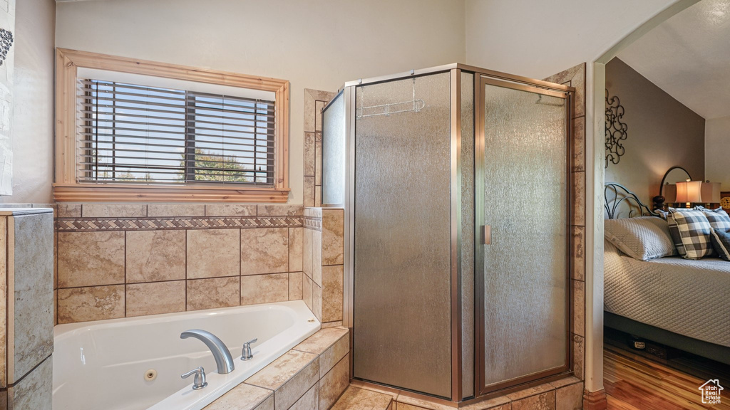 Bathroom featuring ensuite bath, a shower stall, and a tub with jets