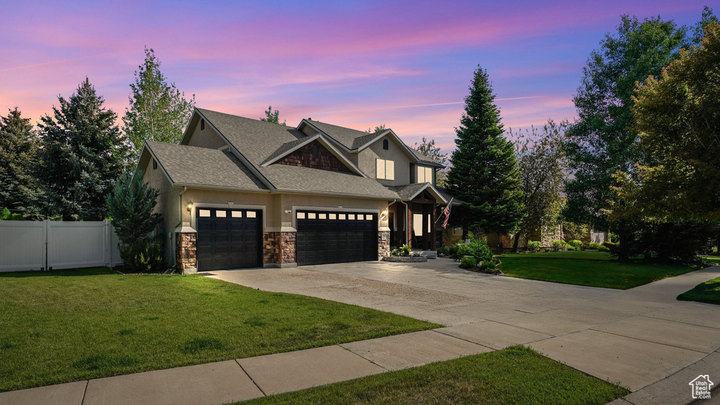 Craftsman-style house featuring driveway, stone siding, a garage, stucco siding, and a shingled roof