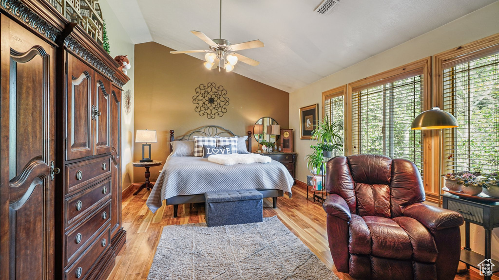 Bedroom featuring lofted ceiling, light wood-type flooring, and baseboards