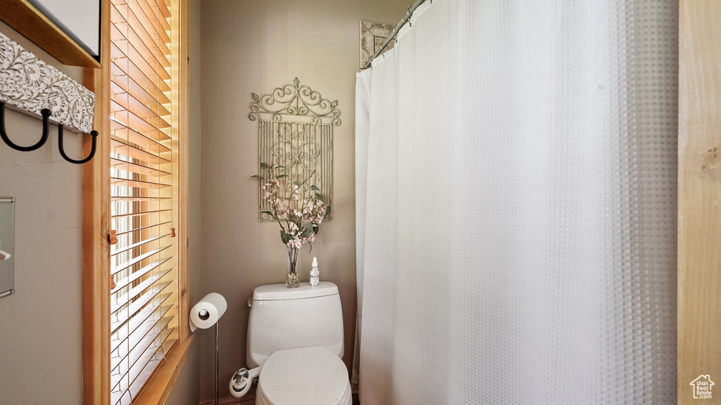 Bathroom with toilet and curtained shower