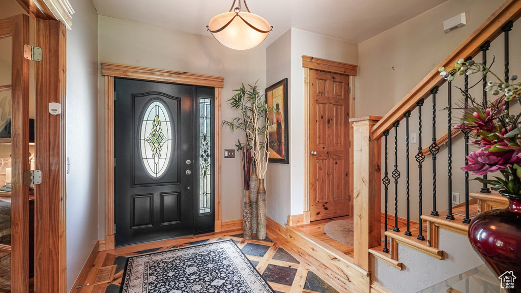 Entryway with stairway, baseboards, and wood finished floors