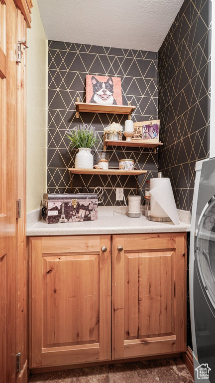 Bar with washer / clothes dryer and a textured ceiling