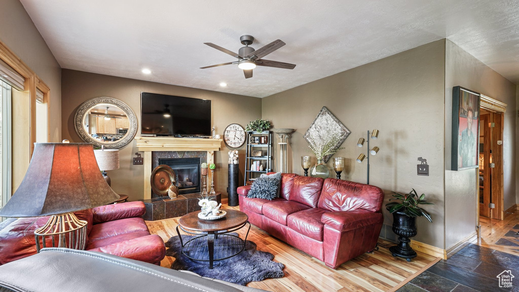Living room featuring ceiling fan, baseboards, a tile fireplace, recessed lighting, and stone finish flooring