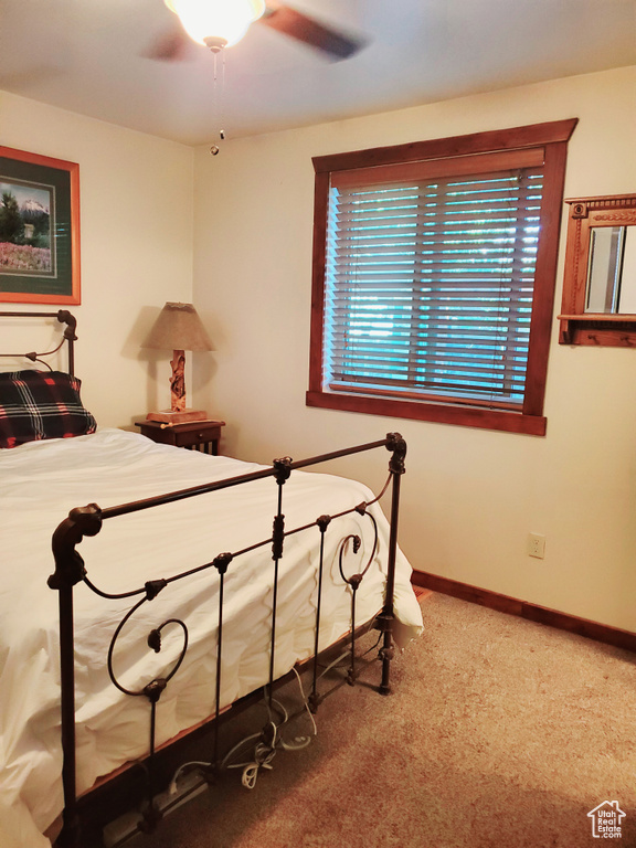 Carpeted bedroom with baseboards and a ceiling fan